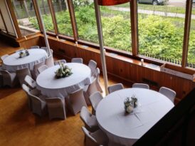 three dining tables next to the huge glass windows